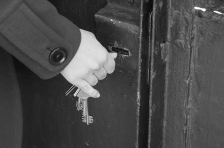 Hand use the key for unlocking door. Monochrome photo.の写真素材