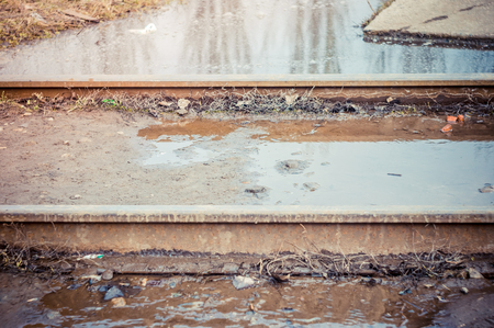 The flooded straight railway track with timber sleepersの写真素材