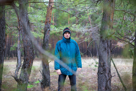 A rural guy posing in a pine forest in the autumn timeの写真素材