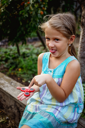 Small cute rural girl doesn't really like fidget spinnerの写真素材