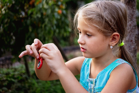 Little girl in the countryside holds a spinner in her handの写真素材