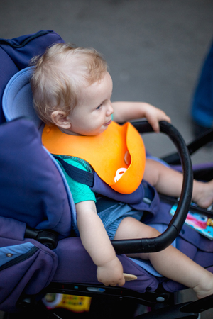 A small cute baby eats in a baby stroller.の写真素材