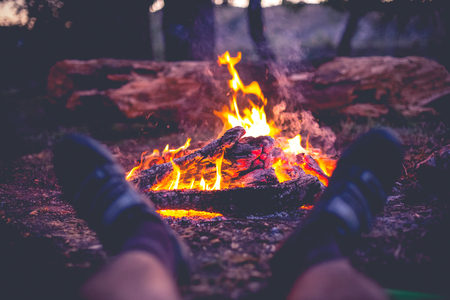 A cyclist resting by the fire in the forest.の写真素材