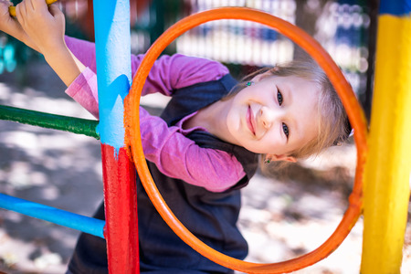 Little cute girl on the playground in the summer.の写真素材