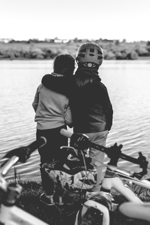 Two cute little girls with bicycles near the pond. Old monochrome styleの写真素材