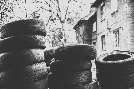 A bunch of old tires from used cars. Environmental pollution. Dump tires. Monochrome photo.の写真素材