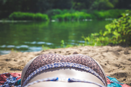 Woman lies on the riverbank in the summer.