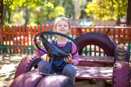 Little cute girl on the playground in the summer.