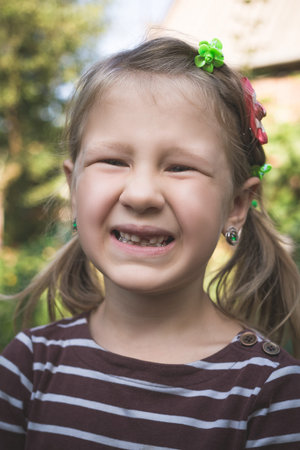 Child with a dental orthodontic device and without one tooth.