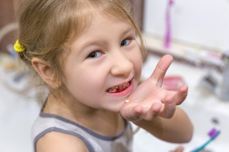 Cute little child has just lost the first milk tooth