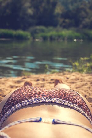 Woman lies on the riverbank in the summer.の写真素材
