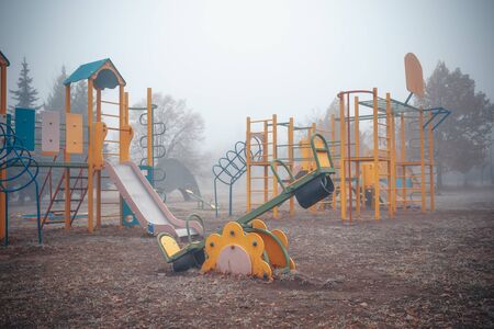 Empty children's playground on a foggy autumn morning.の写真素材