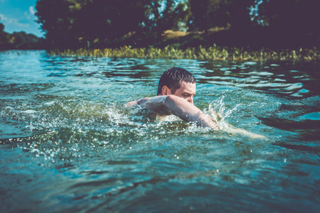 The young man swimming in the river.