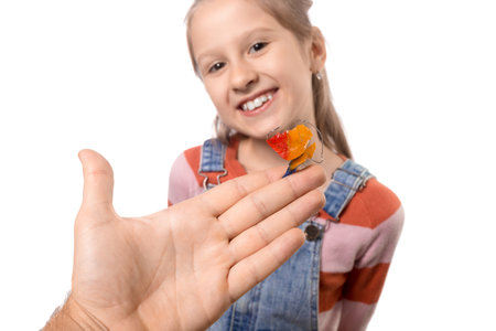 The reaction of a little girl to the proposal to wear an orthodontic appliance. White background.