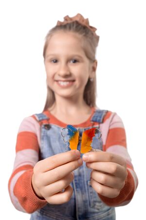 Portrait of little girl with orthodontics appliance isolated on white background.の写真素材