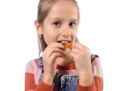 Portrait of little girl with orthodontics appliance isolated on white background.の写真素材