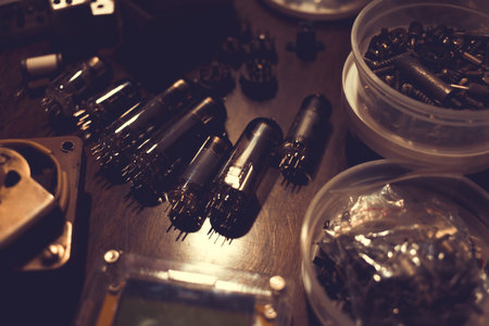 Electronic vacuum tubes and other electronic components on the table. Toned background for design.