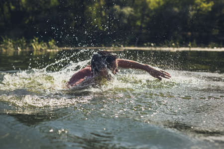 The young man swimming in the river.の写真素材