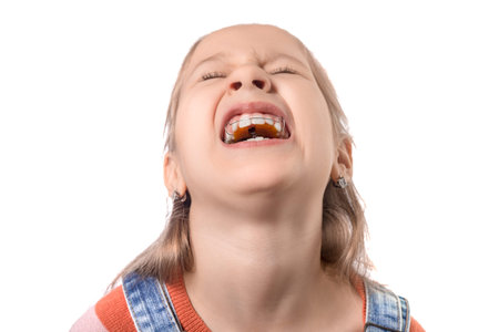 Portrait of little girl with orthodontics appliance isolated on white background.の写真素材