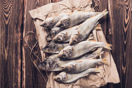 Beautiful dried fish on a paper bag on a wooden table. Studio photo.の写真素材