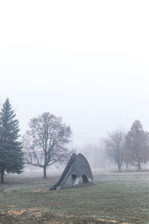 Empty children's playground on a foggy autumn morning.の写真素材