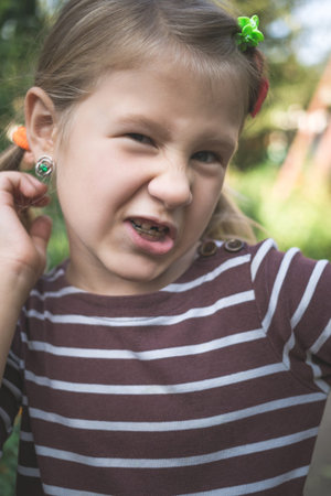 Child with a dental orthodontic device and without one tooth.