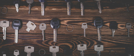 A studio photo of a broken key among many normal keys on a wooden background. Photo in the old style...