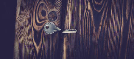 Studio photo of one broken key on a wooden background. Photo with vignettingの写真素材