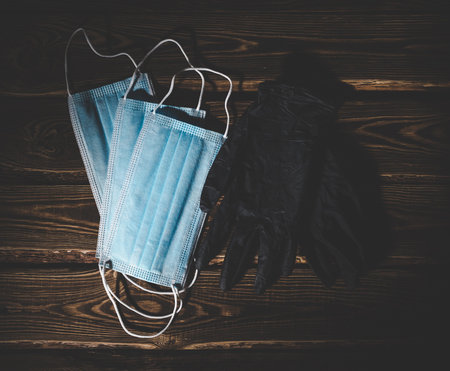 Medical masks and black medical rubber gloves on a wooden background.  virus protection concept. Low...