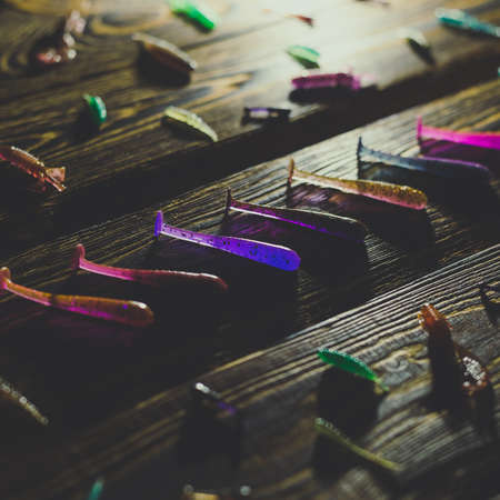 Silicone fish bait on a wooden background. Toned photo studio.の写真素材