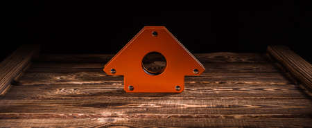 Magnetic corner for welding on a wooden background. A studio photo with hard lighting.の写真素材