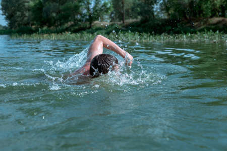 The young man swimming in the river.の写真素材
