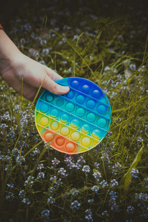 A little cute girl holds in her hand a silicone  - an anti stress toy.の写真素材