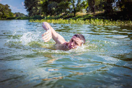 The young man swimming in the river.の写真素材