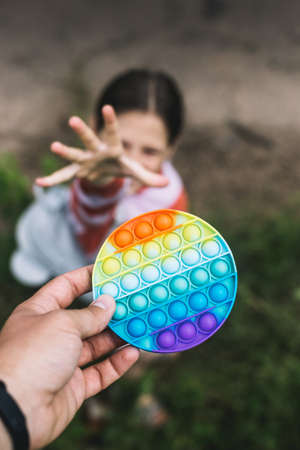 A little cute girl is trying to take away from her father a silicone toy-antistressの写真素材