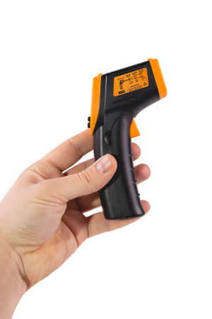 A man holds a yellow-black pyrometer. A device for non-contact temperature measurement. Studio photo of the subject isolated on white background.の写真素材