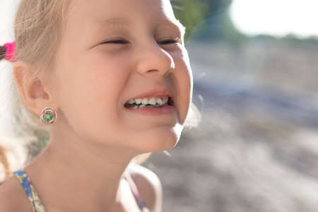 Portrait of a little girl with an outstretched milk tooth.の写真素材