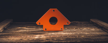 Magnetic corner for welding on a wooden background. A studio photo with hard lighting.の写真素材