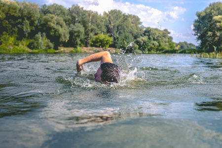 The young man swimming in the river.の写真素材