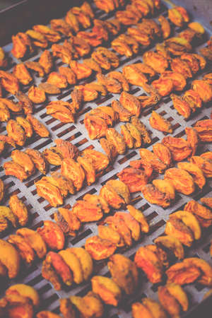 The process of home cooking dried fruits in an electric dryer. The stage of dehydration of fruits for storage and consumption in the winter. Lots of dehydrated apricots.の写真素材