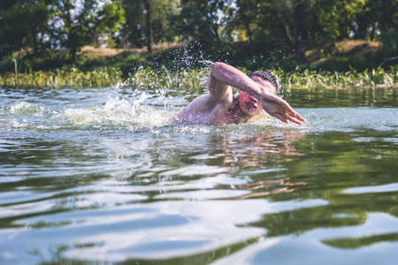 The young man swimming in the river.の写真素材