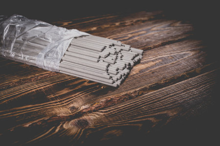 Open pack of welding electrodes on a wooden background. Studio photo in hard light.の写真素材