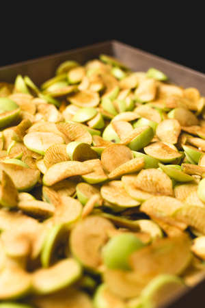 The process of home cooking dried fruits in an electric dryer. The stage of dehydration of fruits for storage and consumption in the winter. Lots of dehydrated apples.の写真素材