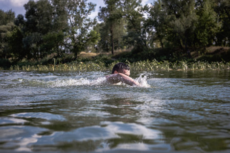 The young man swimming in the river.の写真素材