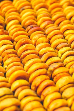 The process of home cooking dried fruits in an electric dryer. The stage of dehydration of fruits for storage and consumption in the winter. Lots of dehydrated apricots.の写真素材