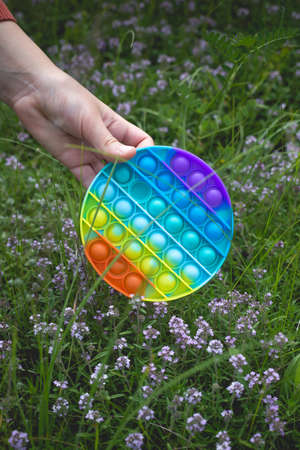 A little cute girl holds in her hand a silicone  - an antistress toy.の写真素材