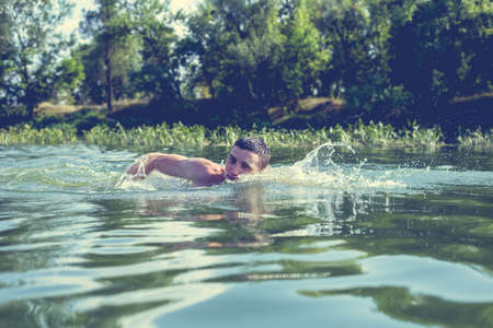 The young man swimming in the river.の写真素材