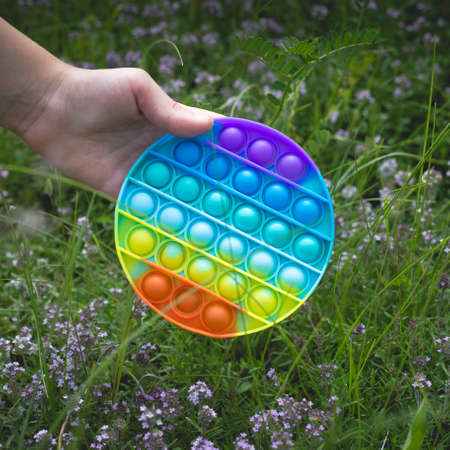 A little cute girl holds in her hand a silicone  - an antistress toy.の写真素材