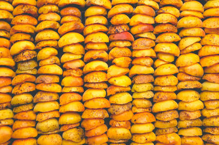 The process of home cooking dried fruits in an electric dryer. The stage of dehydration of fruits for storage and consumption in the winter. Lots of dehydrated apricots.の写真素材