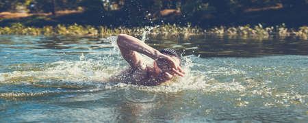 The young man swimming in the river.の写真素材